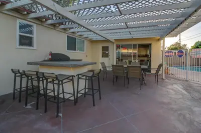 a patio with a bar and chairs under a pergola at F-24 Mickeys House in Anaheim