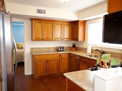 a kitchen with wooden cabinets and a counter top at F-30 Small World in Anaheim