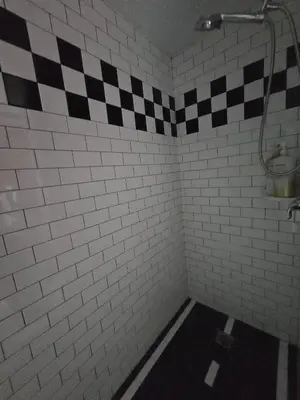 a bathroom with a black and white checkered shower at F-26 Andys House in Anaheim