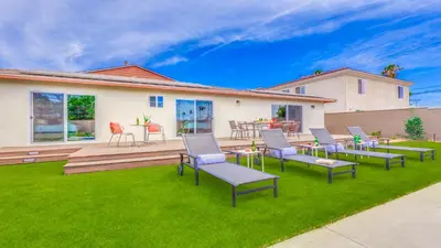 a backyard with chairs and tables on a lawn at F-27 Carnelian in Anaheim
