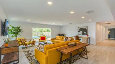 a living room with a yellow couch and chairs at F-27 Carnelian in Anaheim