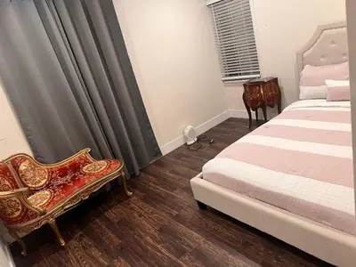 a bedroom with two beds and a chair and a window at Beautiful 2-bedroom downstairs unit by LAX, SoFi, BMO, USC in Los Angeles