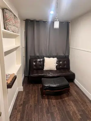 a leather couch in a living room with a curtain at Beautiful 2-bedroom downstairs unit by LAX, SoFi, BMO, USC in Los Angeles