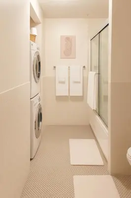 a white bathroom with a washer and dryer in it at Loft in Downtown Los Angeles in Los Angeles