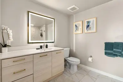 a bathroom with a toilet and a sink and a mirror at Luxury Penthouse 2-BR - with Pool & Gym Access in Los Angeles