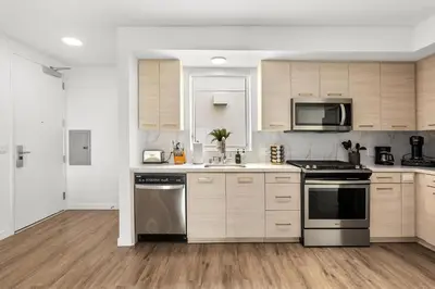 a kitchen with wooden cabinets and stainless steel appliances at Luxury Penthouse 2-BR - with Pool & Gym Access in Los Angeles