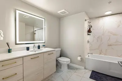 a bathroom with a sink toilet and a mirror at Luxury Penthouse 2-BR - with Pool & Gym Access in Los Angeles