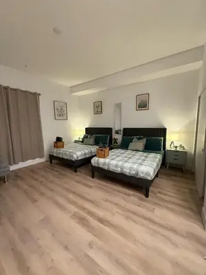 two beds in a large room with wooden floors at Vine Loft FREE DESIGNATED PARKING & WIFI close to Universal Studios in Los Angeles