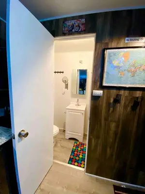 a bathroom with a door open to a bathroom with a toilet at Cozy Container in Devore Heights, California, for Glamping Getaways on Route 66 in Devore Heights