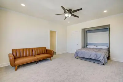 a bedroom with a couch and a bed and a ceiling fan at Long Beach Panorama in Long Beach