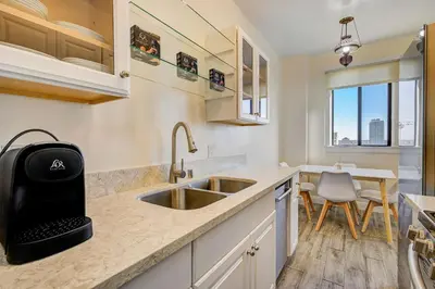 a kitchen with a sink and a table with chairs at Long Beach Panorama in Long Beach