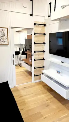a living room with white cabinets and a tv at Tiny House Living with In Unit Laundry Steps from Kaiser in Litton Industries Heliport
