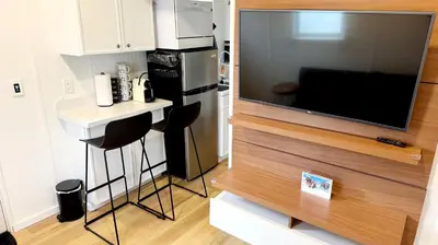 a small kitchen with a small table and a television at Tiny House Living with In Unit Laundry Steps from Kaiser in Litton Industries Heliport