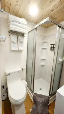 a bathroom with a toilet and a shower with towels at Tiny House Living with In Unit Laundry Steps from Kaiser in Litton Industries Heliport