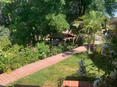 a garden with a brick walkway with a bench at charming guest house in Hidden Hills