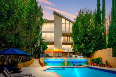 a swimming pool in front of a building at 6BR-Music Studio-Pool-Spa & Games in Sherman Oaks