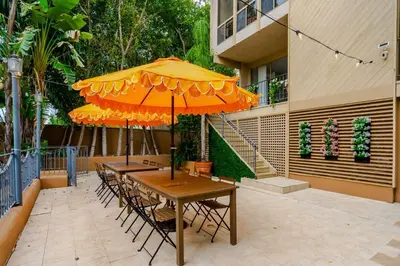 two tables and chairs under an umbrella on a patio at 6BR-Music Studio-Pool-Spa & Games in Sherman Oaks