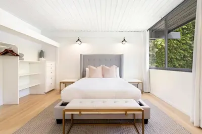 a bedroom with a white bed and a large window at Malibu Reserve by Stay Awhile Villas in Malibu