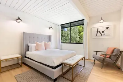 a bedroom with a large bed and a chair at Malibu Reserve by Stay Awhile Villas in Malibu