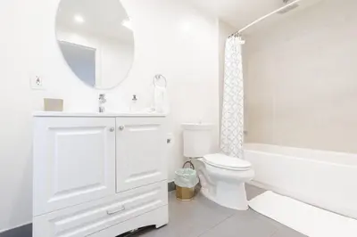 a white bathroom with a tub and a toilet and a sink at Mulholland Drive with Spa & Game Room in Los Angeles