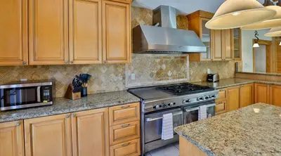 a kitchen with wooden cabinets and a stove top oven at City Paradise Saltwater Pool-Spa and Ping-Pong in Los Angeles