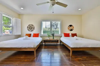 a bedroom with two beds and a ceiling fan at City Paradise Saltwater Pool-Spa and Ping-Pong in Los Angeles