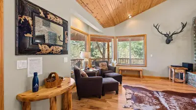 a living room with a couch and a table at Sleeps 27 2 Homes Near the Lake Hot Tub Views Castle Glen Estates in Big Bear Lake