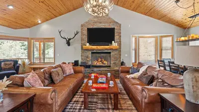 a living room with leather couches and a fireplace at Sleeps 27 2 Homes Near the Lake Hot Tub Views Castle Glen Estates in Big Bear Lake