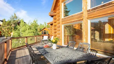 a wooden deck with a table and chairs at Sleeps 27 2 Homes Near the Lake Hot Tub Views Castle Glen Estates in Big Bear Lake