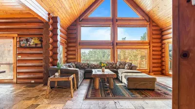 a living room with a couch and a table at Sleeps 27 2 Homes Near the Lake Hot Tub Views Castle Glen Estates in Big Bear Lake