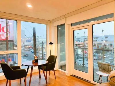a room with a table and chairs and a large window at Boutique KTown Stays With Breathtaking Rooftop Views in Los Angeles