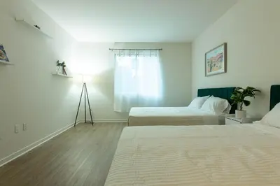 a room with two beds and a lamp in it at Elegant & Charming 2BR Apartment in Glendale