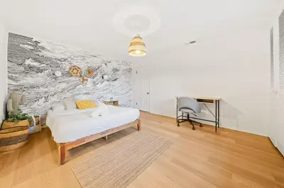 a white bedroom with a bed and a desk at Pool & Spa Ping-Pong Mini-Golf & 5BR in Sherman Oaks