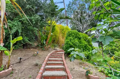 a garden with a brick path in the middle at The Robinson Tree House in Silver Lake in Los Angeles