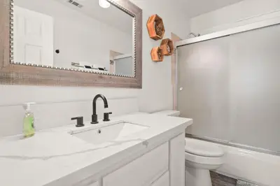 a white bathroom with a sink and a toilet at Hummingbird Corner Pet Friendly Great Location Jacuzzi in Big Bear Lake