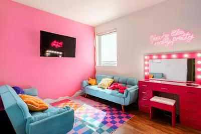 a room with two blue chairs and a pink wall at Colorful penthouse near DTLA in Los Angeles