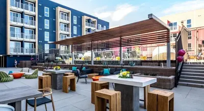a rooftop patio with tables and chairs and buildings at Colorful penthouse near DTLA in Los Angeles