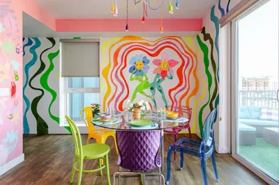 a dining room with a table with chairs and a colorful wall at Colorful penthouse near DTLA in Los Angeles