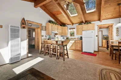 a kitchen and dining room with wooden cabinets at Comstock Cabin by Rather Be Properties in Big Bear Lake