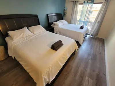 two beds in a hotel room with a towel on them at Great Location Double Queen Bed Unit in Los Angeles