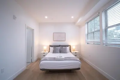 a white bedroom with a bed and two windows at Stylish Private Room by Downtown LA with Private Parking in Los Angeles