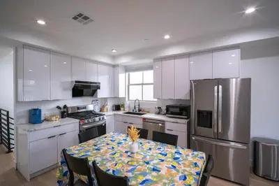 a kitchen with white cabinets and a table with a table cloth at Stylish Private Room by Downtown LA with Private Parking in Los Angeles