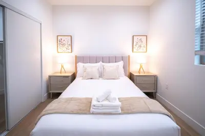 a bedroom with a large white bed with towels on it at Stylish Private Room by Downtown LA in Los Angeles