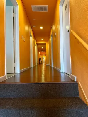 an empty hallway of a building with orange walls at Plaza Hotel Gardena in Gardena