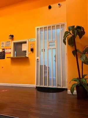 an orange room with a door with a plant at Plaza Hotel Gardena in Gardena