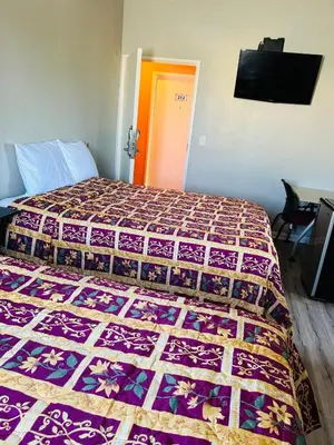a bedroom with a bed with a quilt on it at Plaza Hotel Gardena in Gardena