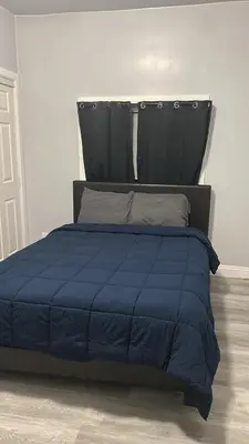 a bed with a blue comforter in a bedroom at Hollywood Homes of Love in Los Angeles