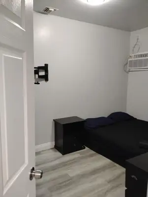 a bedroom with a black bed and a door at Hollywood Homes of Love in Los Angeles