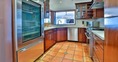 a kitchen with wooden cabinets and a stainless steel refrigerator at Estate with Heated Pool & Jacuzzi & Tennis Court in Sherman Oaks Community Hospital Heliport