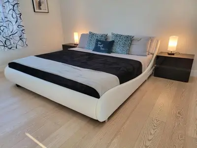 a large bed in a bedroom with two night stands at Newly constructed 2 bedroom by La Cienega Plaza with parking, modern kitchen, washer dryer and very central to attractions in Los Angeles